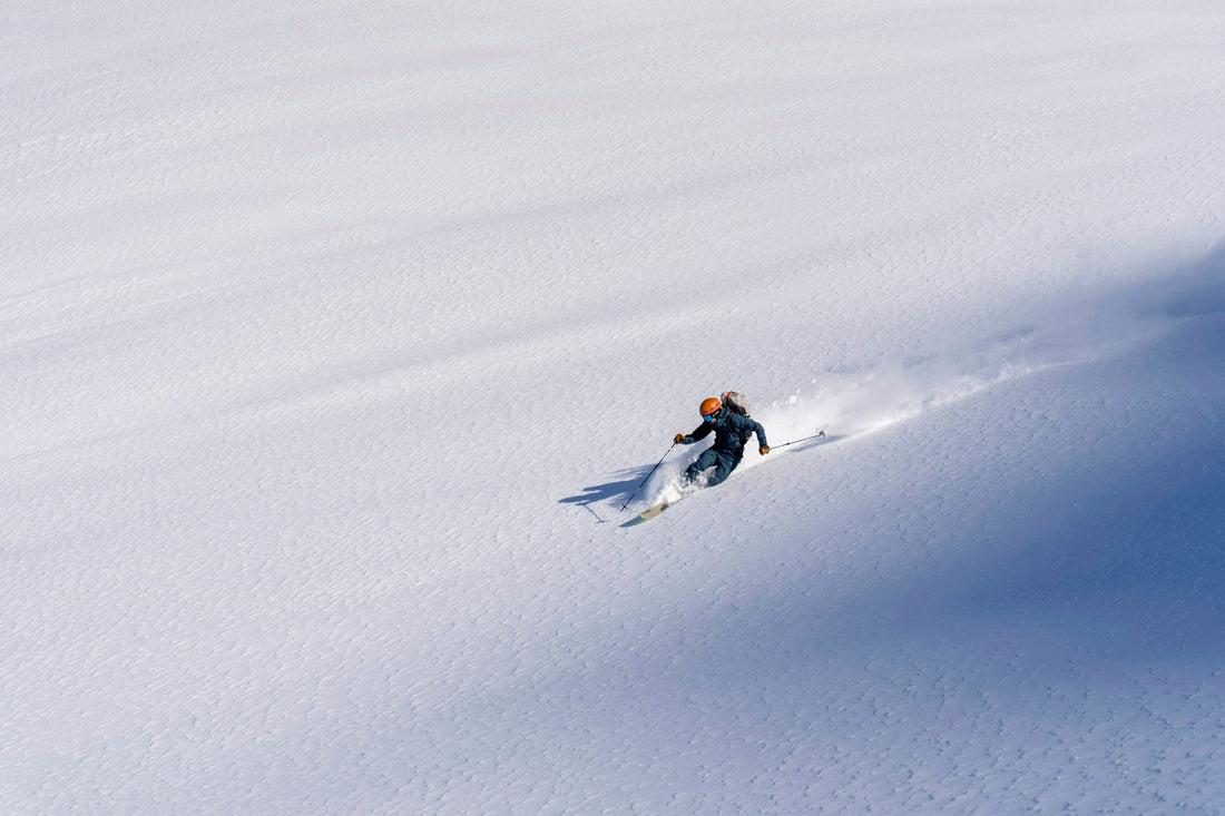 A skier carving untracked snow.
