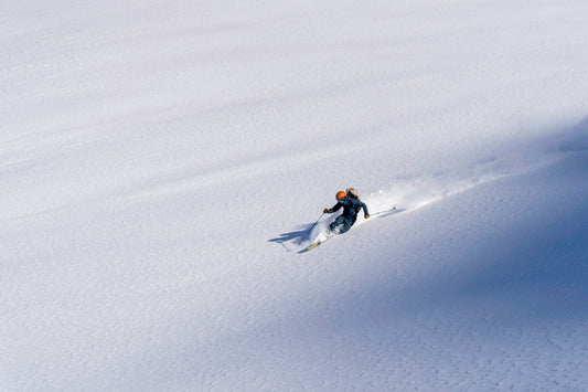 A skier carving untracked snow.